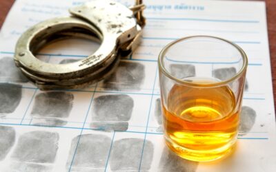 A glass of alcohol sits on papers after an arrest. Can I get a federal job with a DUI?