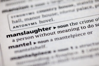 Text of the word “manslaughter” in bold on a piece of paper with a definition and examples of voluntary manslaughter following it