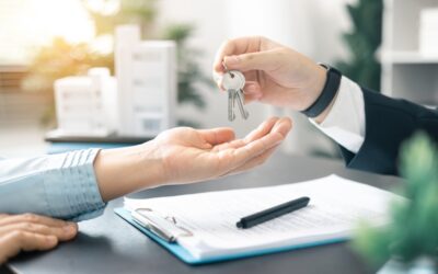 A real estate agent handing the keys to a client. Can you be a real estate agent with a DUI?