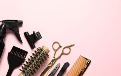 Hair dresser tools arranged on a pink background