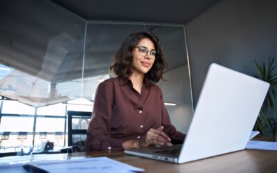 A woman with a dui working in IT or tech sitting at her laptop.