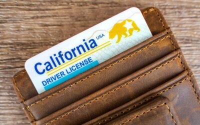 A California driver’s license in a brown letter wallet sits on a wood table after the driver lost two points for a DUI.